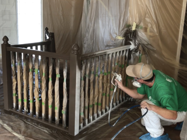 Spray applying first coat of paint to staircase