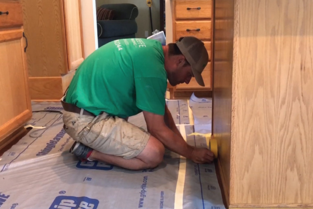 Using yellow frog tape along edges to cover floors