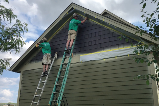 Masking soffits before painting shakes on this Rosemount Home